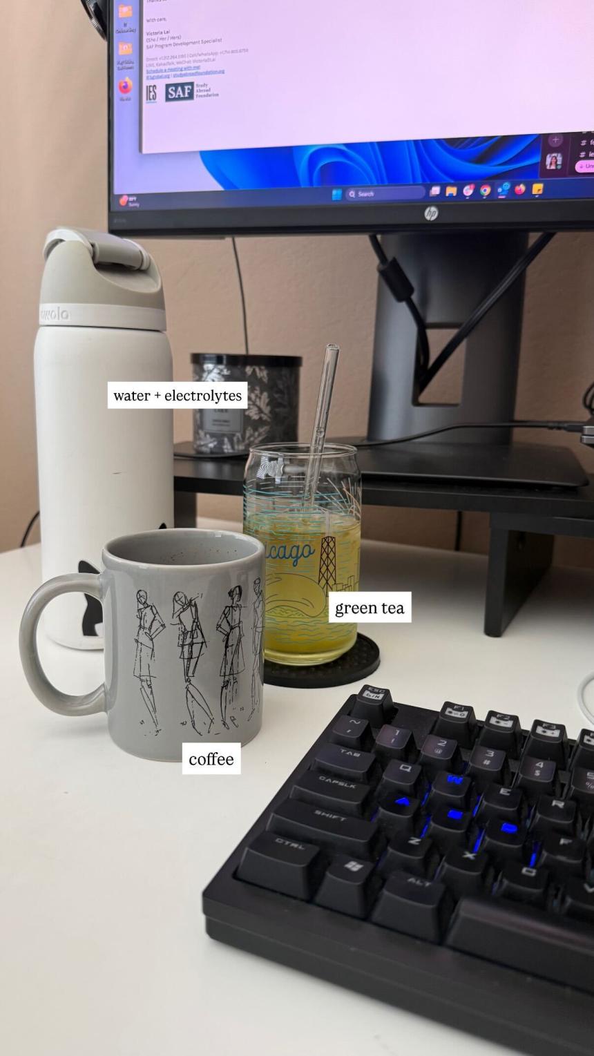 3 drinks at Victoria Lai's desk, labeled with text: water + electrolytes, green tea and coffee