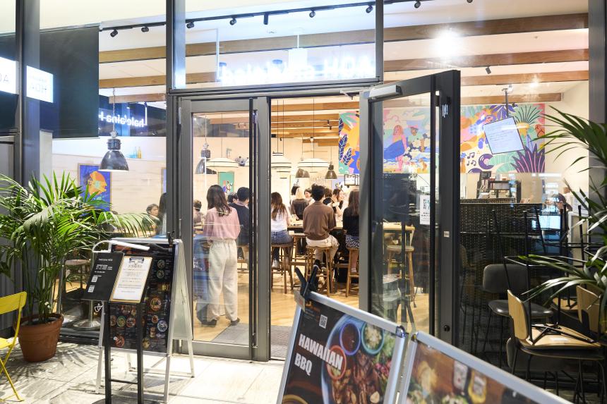 Outside the SAF Japan Alumni Party venue restaurant, ads for food on display and door open.