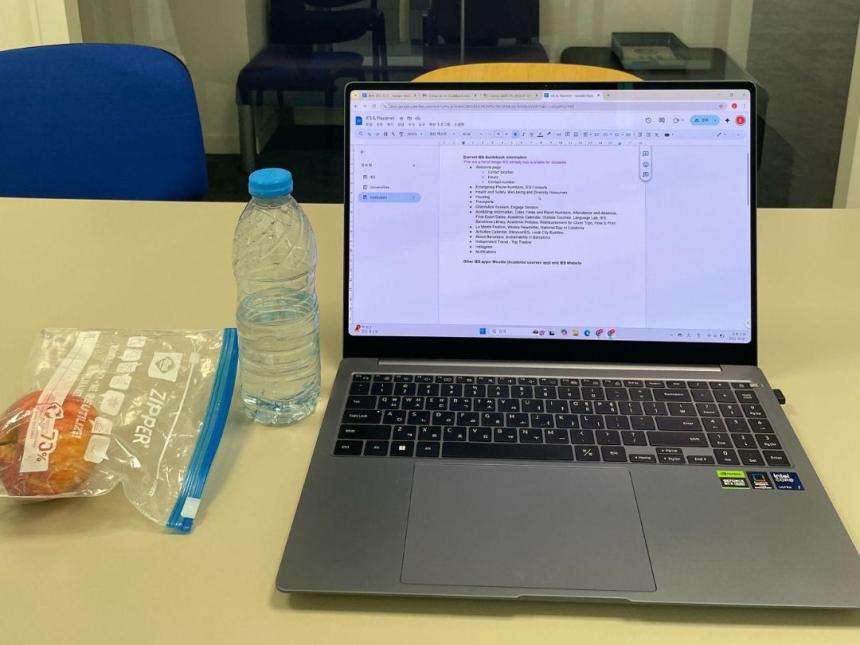 Laptop open on a Google Doc, snack and water bottle nearby.