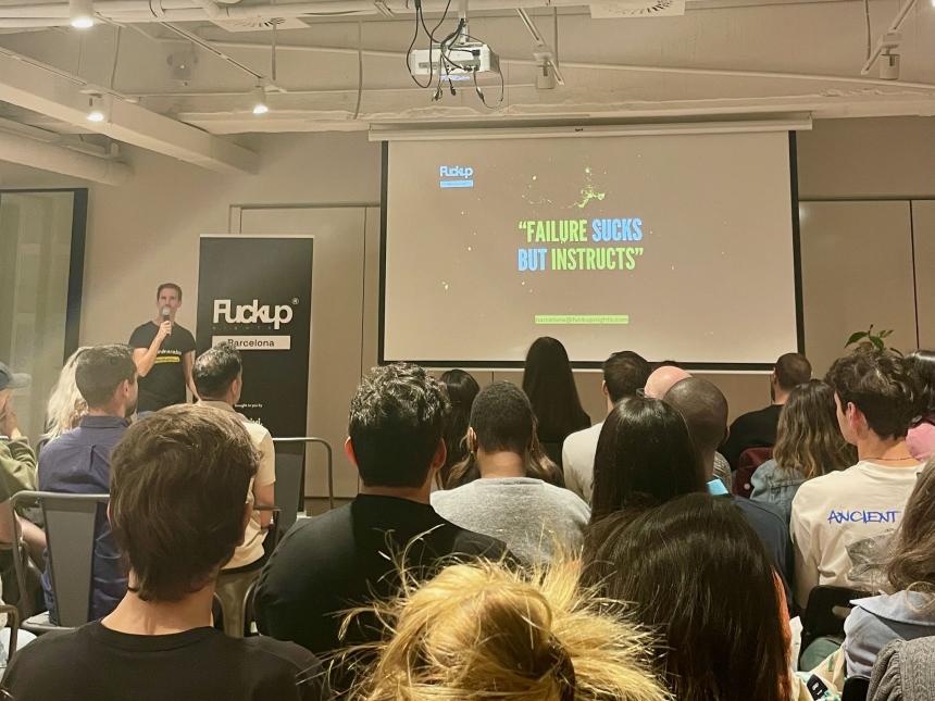 Presentation in a room full of students, slide reading, "failure sucks but instructs."