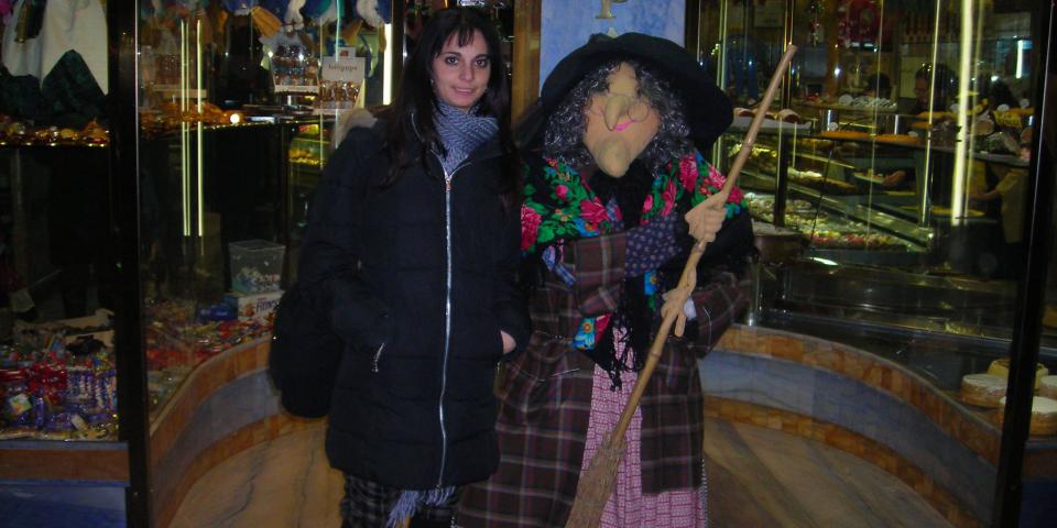 A woman stood next an Italian La Befana festive witch