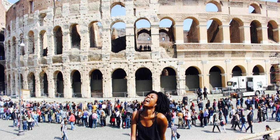 Student laughing sat in front of the Rome Colosseum