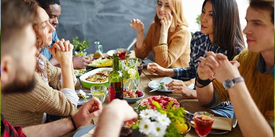 Students sat around a table eating and chatting