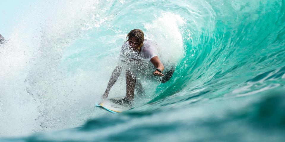 a man surfing surrounded by a wave