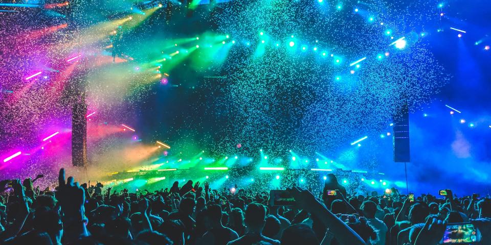 colorful lights and confetti light up the darkness of a concert